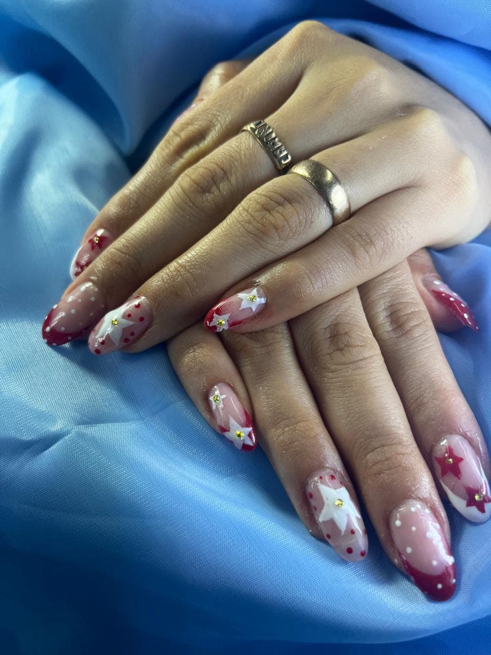 Uñas con francés rojo, estrellas blancas y cristales